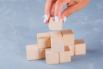Immagine: hand-putting-stacking-wooden-cubes
