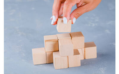 Immagine: hand-putting-stacking-wooden-cubes